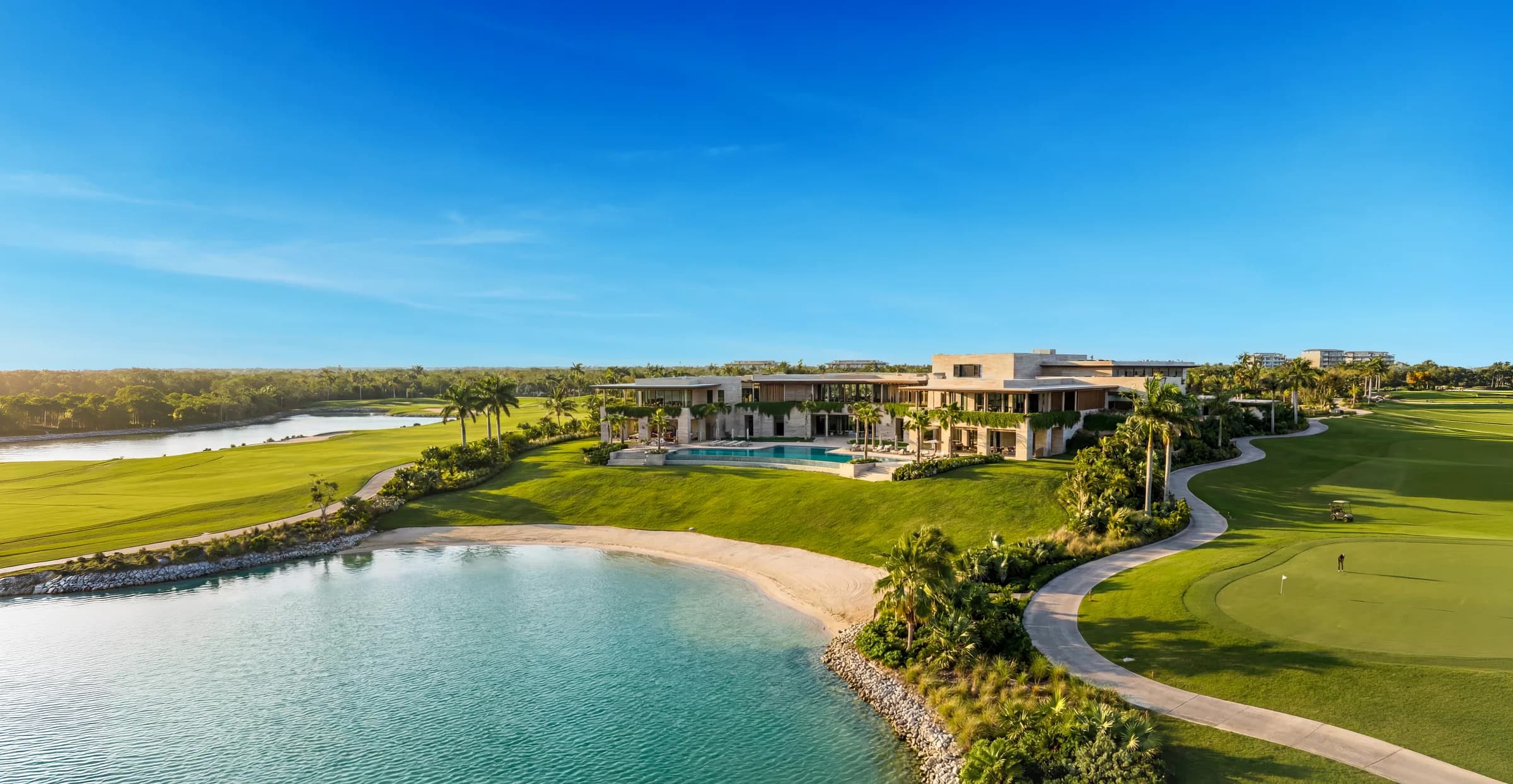 Vista aérea del Golf Club de Country Lakes — casa club, alberca, campo par 72 y lago